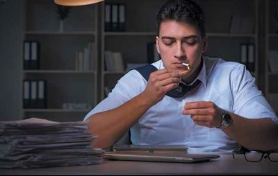 Man smoking in a room full of binders